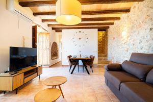a living room with a couch and a table with a clock at Villa Sa Costa - Families or Couples Only in Calvià