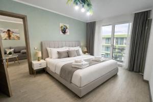 a bedroom with a white bed and a large window at Alezzi Beach Resort - Sea View Suite in Mamaia Sat/Năvodari +131 photos