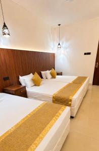 a hotel room with two beds and two lights at Thambara Resort in Polonnaruwa