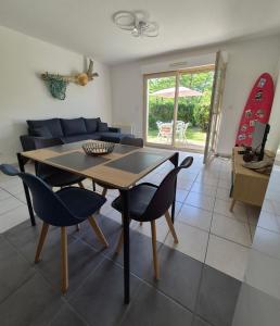 a dining room and living room with a table and chairs at Le Cocon Litois in Lit-et-Mixe
