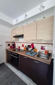 a kitchen with wooden cabinets and a sink and a stove at Le Cocon Litois in Lit-et-Mixe
