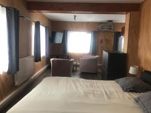 a bedroom with a bed and two chairs and a window at Loc Appart SPM in Saint-Pierre