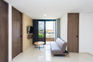 a living room with a couch and a table at Hotel Distrito 70 Living in Medellín
