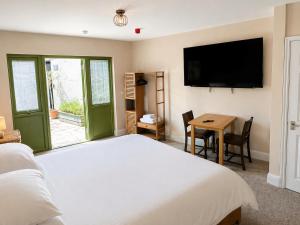 a bedroom with a bed and a table and a television at The Olive in Market Rasen