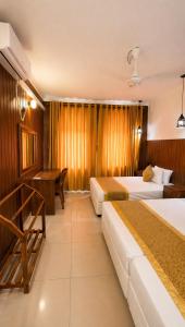 a hotel room with two beds and a desk at Thambara Resort in Polonnaruwa