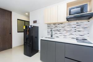 a kitchen with a black refrigerator and a microwave at Hotel Distrito 70 Living in Medellín +22 photos