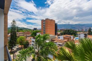a view of a city with buildings and palm trees at Hotel Distrito 70 Living in Medellín