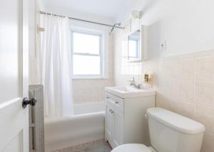 a bathroom with a toilet and a sink and a tub at 152 Quite & Bright & Spacious Apt in Brighton in Boston