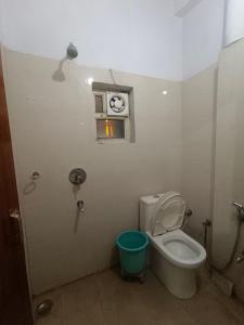 a bathroom with a toilet and a clock on the wall at Hotel King's Residency in Narendranagar