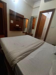 a bedroom with a white bed with a large mirror at Hotel King's Residency in Narendranagar +1 photo