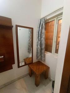 a mirror and a bench in a room with a window at Hotel King's Residency in Narendranagar