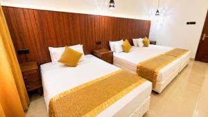 a hotel room with two beds in a room at Thambara Resort in Polonnaruwa +39 photos