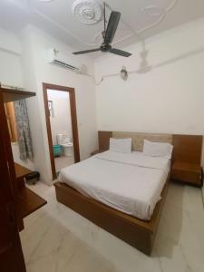 a bedroom with a bed and a ceiling fan at Hotel King's Residency in Narendranagar