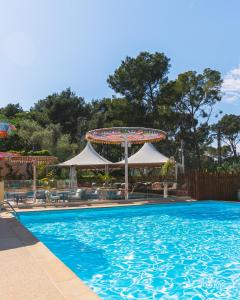 a large swimming pool with a theme park at Le Beau Vezé in Carqueiranne