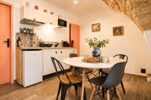 a kitchen and dining room with a table and chairs at L'écrin du Pont du Gard - Parking gratuit - Charme & Pierres in Remoulins