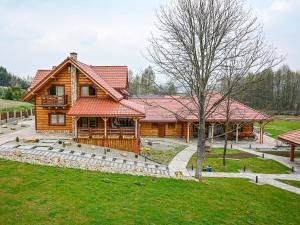 a large log cabin with a tree in front of it at Domki Markowa Dolina in Rymanów
