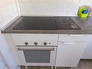 a white kitchen with a stove top oven at Piso Buenos Aires in Cee