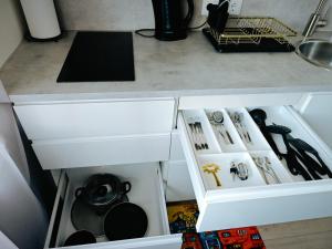 a kitchen counter with a white drawer with utensils at ArSa in Ventspils