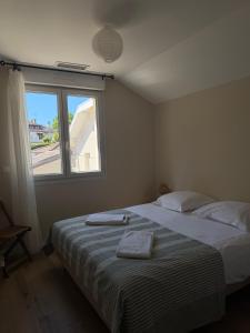 a bedroom with a bed with two towels on it at Lamayade in Arcachon