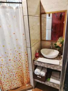 a bathroom with a sink and a shower curtain at Reserva Natural Cerro Alto in Empalme