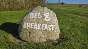 a rock with the words bed and breakfast written on it at Sov Godt i Arnborg Bed & Breakfast in Arnborg