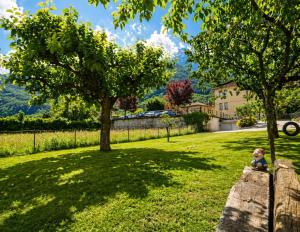 a child sitting on a wall in a yard at Casa Didi & Rosi - Lake Como in Colico