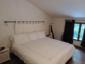 a bedroom with a white bed and a window at 43 Rue des Quarts in Ménesplet