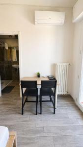 a dining room with a table and two chairs at Modena Station - Suite H24 in Modena