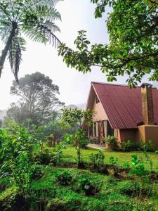 a house with a red roof in a green field at Reserva Natural Cerro Alto in Empalme