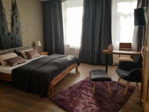 a bedroom with a bed and a chair and a desk at Pension am Park in Oschatz
