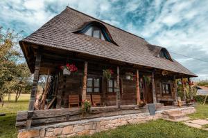 a log cabin with flowers on the porch at Maramureș Traditional House in Vadu Izei