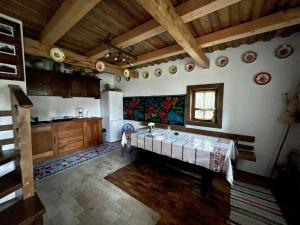 a kitchen with a table and a sink in it at Maramureș Traditional House in Vadu Izei