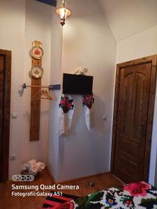 a bedroom with a tv on a wall with flowers at Maramureș Traditional House in Vadu Izei