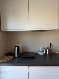 a kitchen with white cabinets and a black counter top at Lamayade in Arcachon