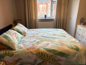 a bed with a colorful comforter in a bedroom at Central Mablethorpe Apartment in Mablethorpe