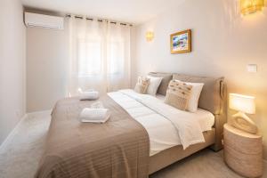 a bedroom with a large bed with two towels on it at CASA LEONE - fully renovated since April 2026 - new pictures in Carvoeiro +16 photos