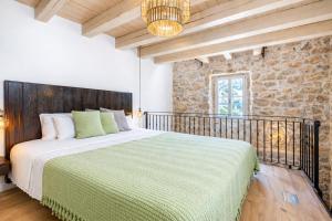 a bedroom with a bed and a stone wall at Deluxe Nature Resort Galovi Dvori in Rab +34 photos