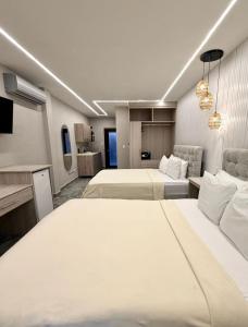 a hotel room with two beds and a couch at Caye Caulker Condos in Caye Caulker