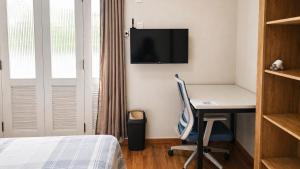 a bedroom with a desk with a computer and a tv at Recanto Paraense in Belém