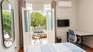 a bedroom with a bed and a desk and a window at Recanto Paraense in Belém