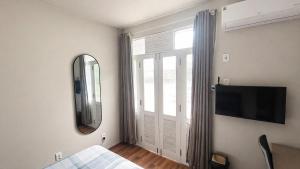 a bedroom with a mirror and a bed and a tv at Recanto Paraense in Belém