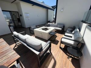 a living room with couches and a table and chairs at MOTTO Executive Stays Condominium in Hércules