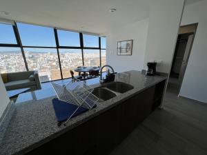 a kitchen with a sink and a view of a city at MOTTO Executive Stays Condominium in Hércules