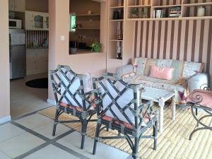 a living room with a couch and a table and chairs at CosyNest Apartment in Cap Malheureux