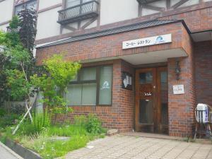 a brick building with a sign above the door at Resort Inn Murata in Iiyama