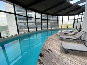 a large swimming pool in a building with windows at MOTTO Executive Stays Condominium in Hércules