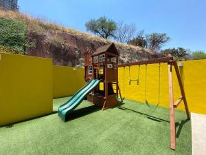 a playground with a slide and a play house at MOTTO Executive Stays Condominium in Hércules