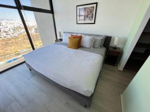 a large bed in a room with a large window at MOTTO Executive Stays Condominium in Hércules +23 photos