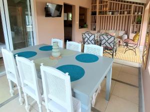 a white dining room table with white chairs at CosyNest Apartment in Cap Malheureux +37 photos