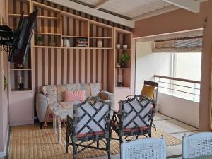 a living room with a couch and a table and chairs at CosyNest Apartment in Cap Malheureux
